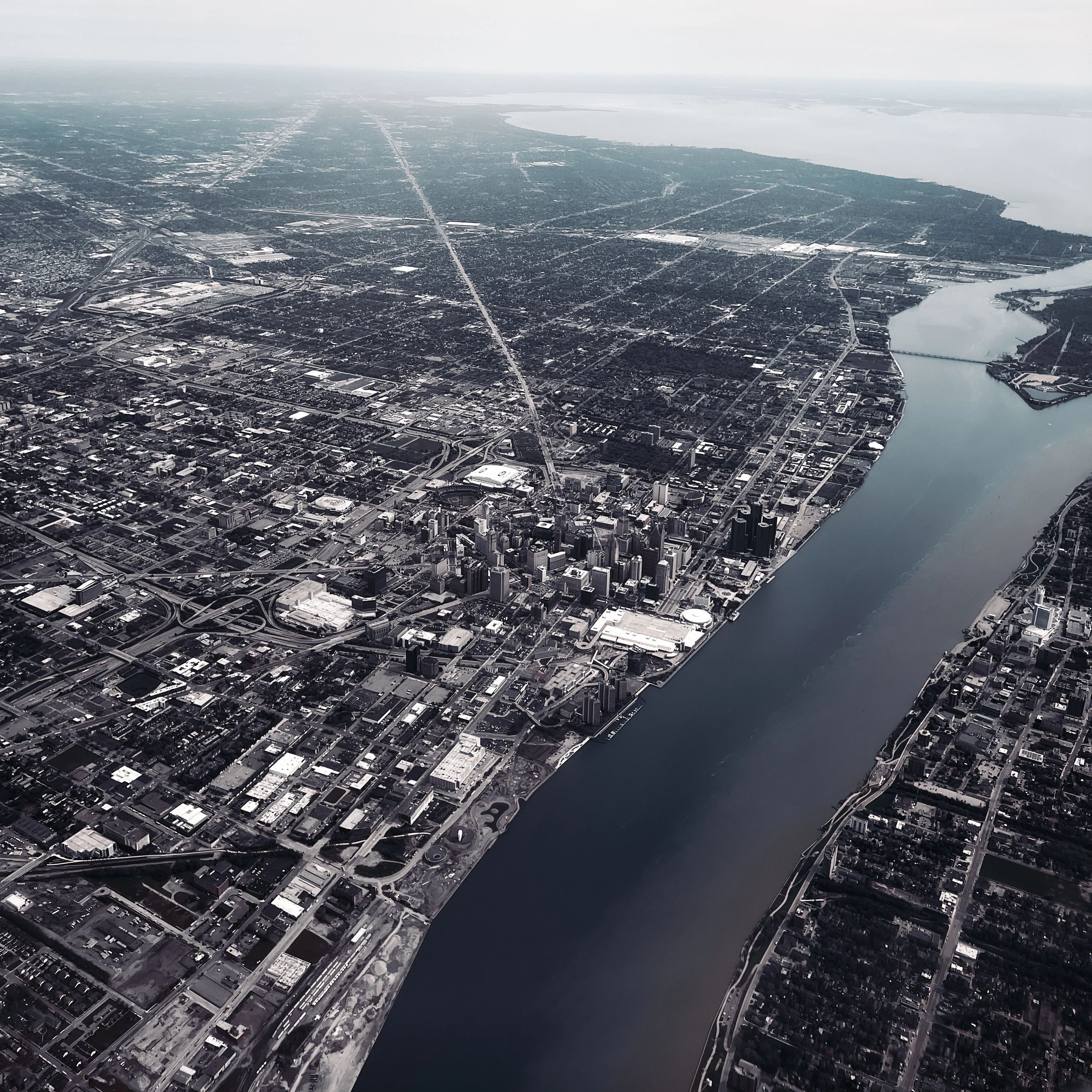 Aerial view of a city by a wide river with dense urban buildings.