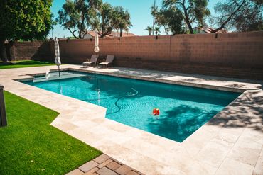 Synthetic turf lawn beside modern pool deck and seating areas