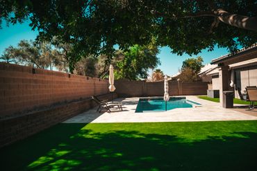Pool deck jets creating water arcs over refreshed tile and coping