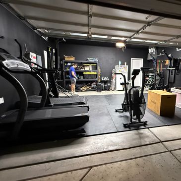Home gym setup with exercise equipment and a person in the background.