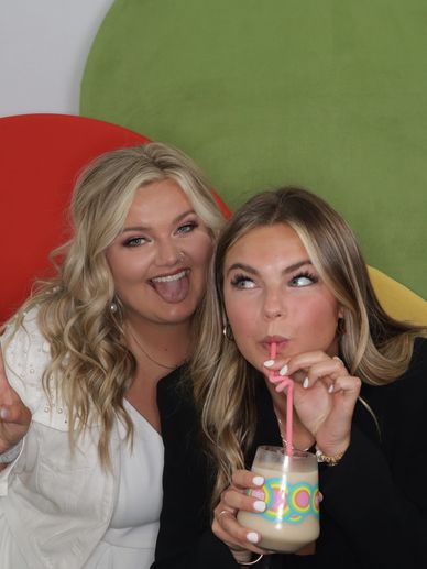 two young women smiling and posing in front of camera.