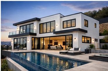 Modern two-story house with large windows and a swimming pool at sunset.