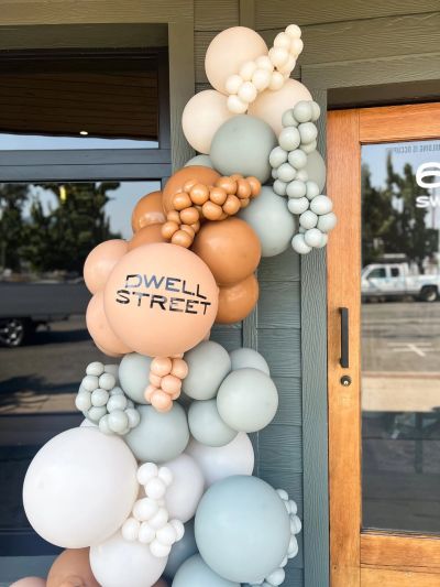 Balloon arrangement with Dwell Street text near a door.