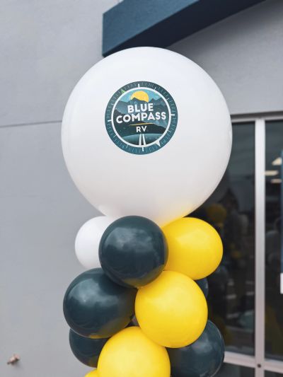 Balloons branded with Blue Compass RV logo.