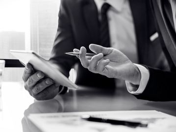 Two businessmen discussing with a tablet in a modern office.