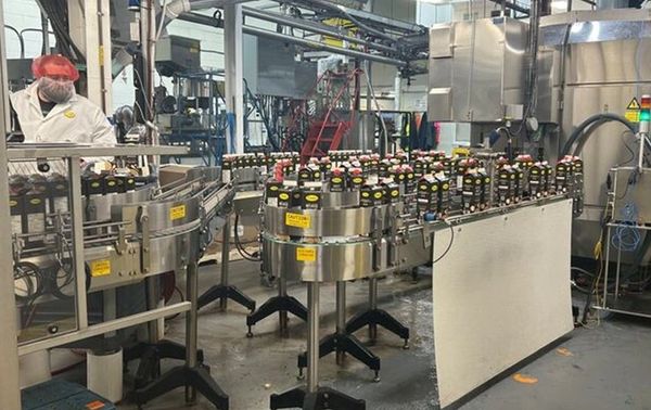 Bottles on a conveyor belt in a factory setting.