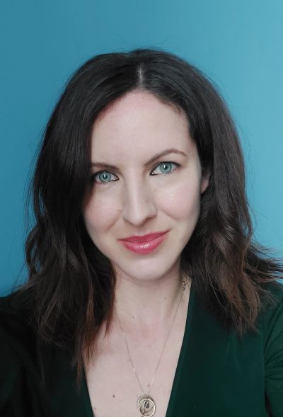 Woman with blue eyes and dark hair smiling.