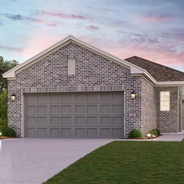 Modern brick house with a large gray garage door and a neat lawn at sunset.