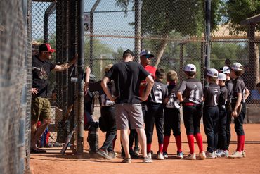 Head Coach Christian Lara and assistant coaches have a postgame huddle to teach and learn.