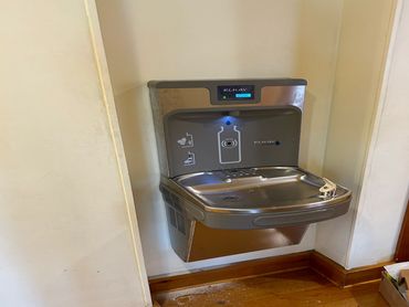 Modern Elkay water fountain with bottle refill station mounted on a wall.