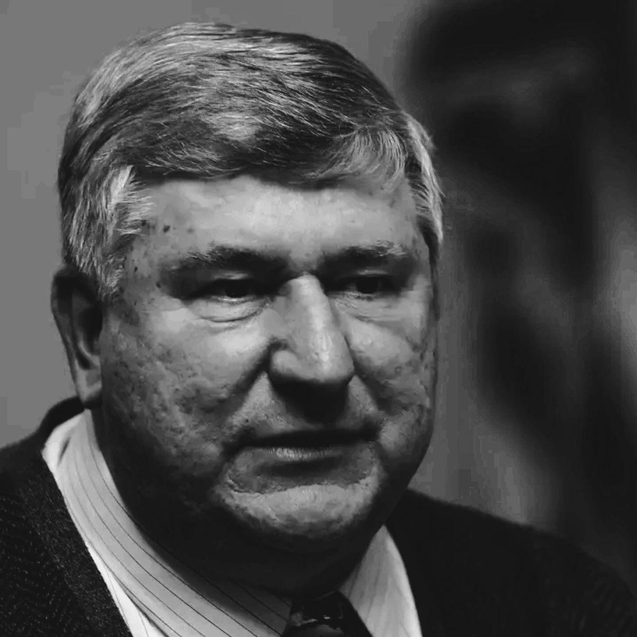 Black and white portrait of a middle-aged man with gray hair.