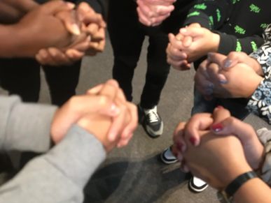 Photo of a group of peoples' hands clasped together for 'Worshipping Together'.