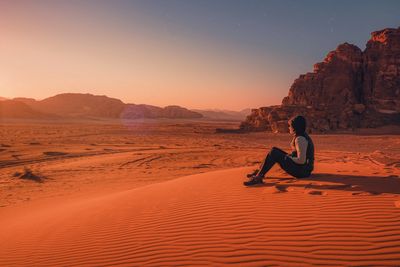 a woman sitting on sand