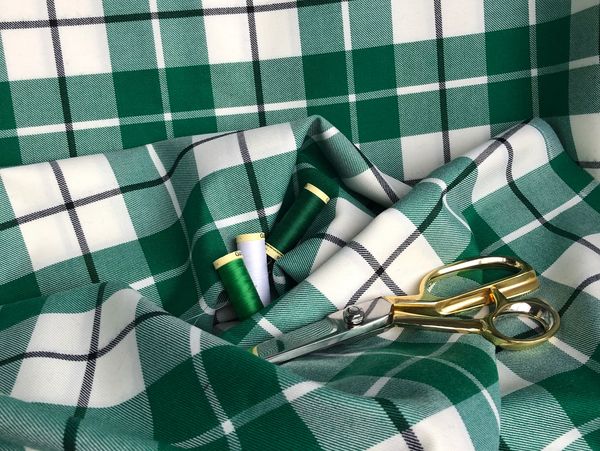 Green kilt material with golden scissors over it