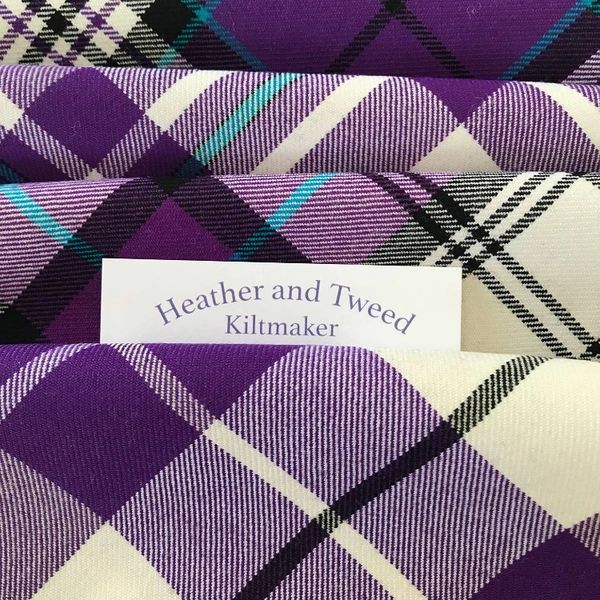 Kilt material in purple shades with a business card in between