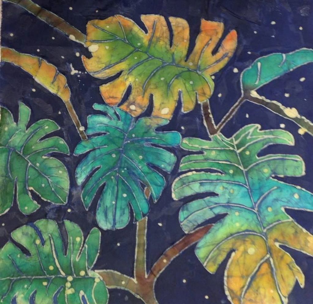 Batik with blue, green and yellow colored leaves on navy background.
