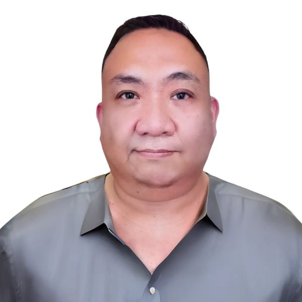Portrait of a man with a neutral expression wearing a gray shirt against a white background.
