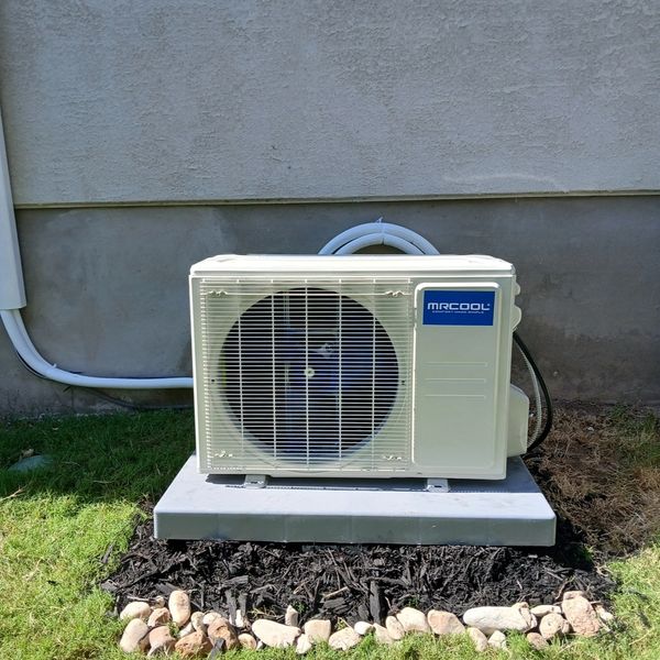 Outdoor air conditioning unit installed outside a house.