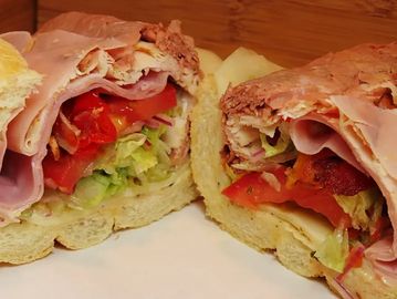 Two sandwiches with slices of meat and vegetables