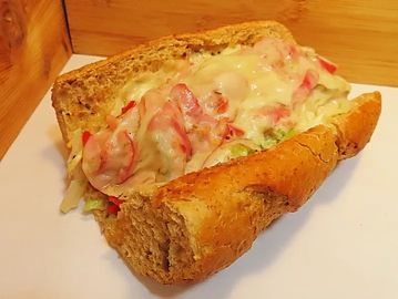 A sandwich with vegetables and melted cheese