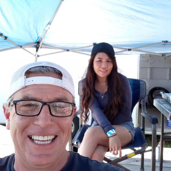 Smiling man and woman under canopy.