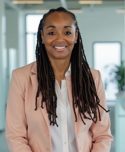 Confident woman with long braids smiling in a professional setting.
