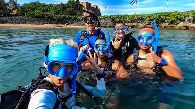 PADI Open Water SCUBA Diver course. Adventure Mermaid Crew with divers standing in shallow water.