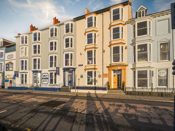 Row of colorful bay-windowed hotels under a clear sky.