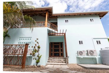 Modern two-story house with wooden accents and a stone path entrance.