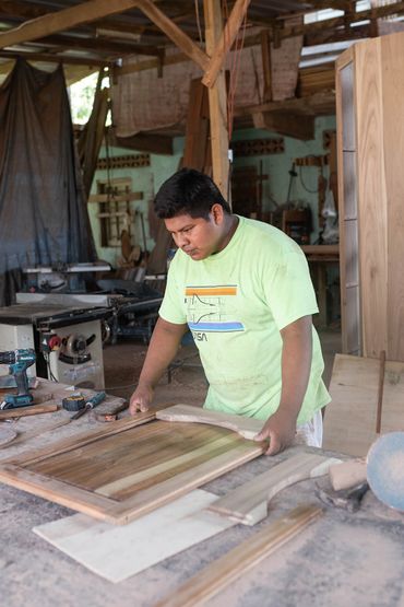 A man working on a wooden frame in a carpentry workshop.
