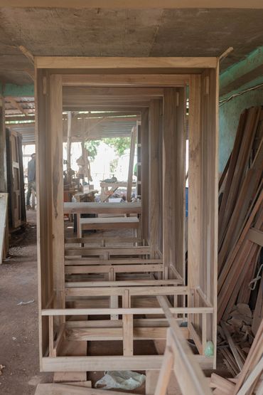 Unfinished wooden furniture frames in a carpentry workshop.