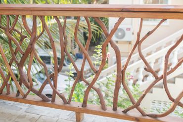 Rustic wooden railing made from natural branches on a balcony.