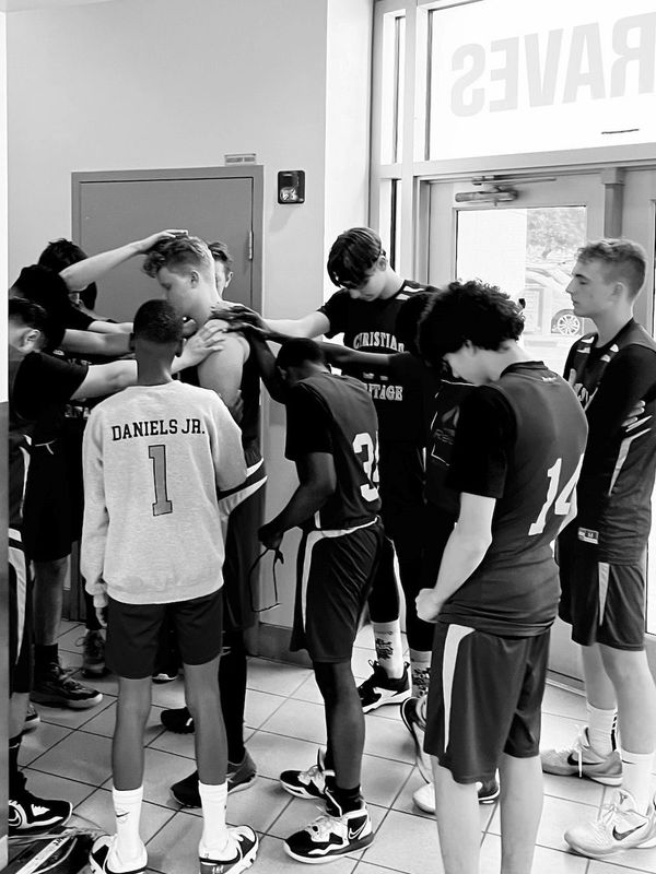 JV basketball team praying over a teammate who is starting a new adventure in life. 