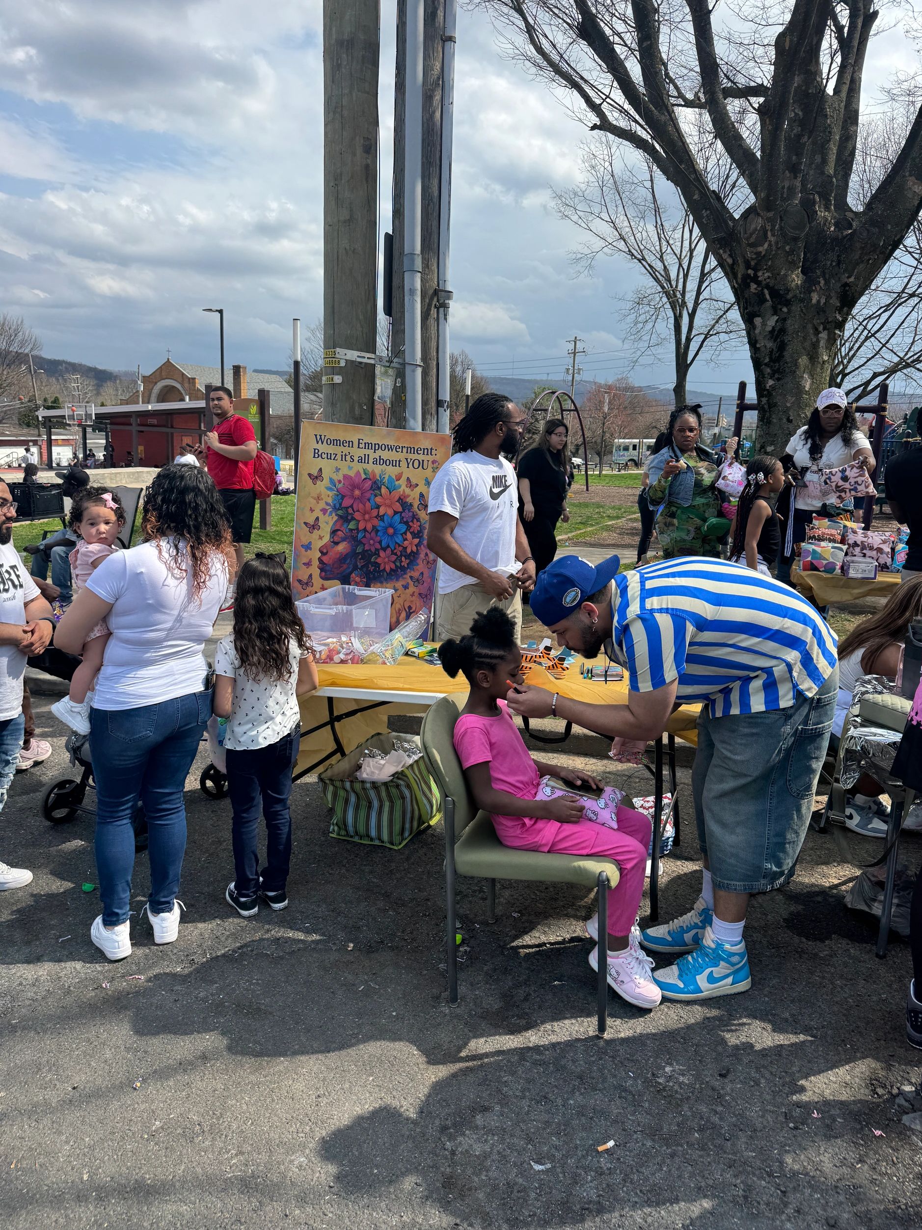 Women, children, and volunteers creating joyful connections at a community event.