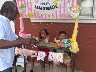 Two kids running a lemonade stand while a man approaches.