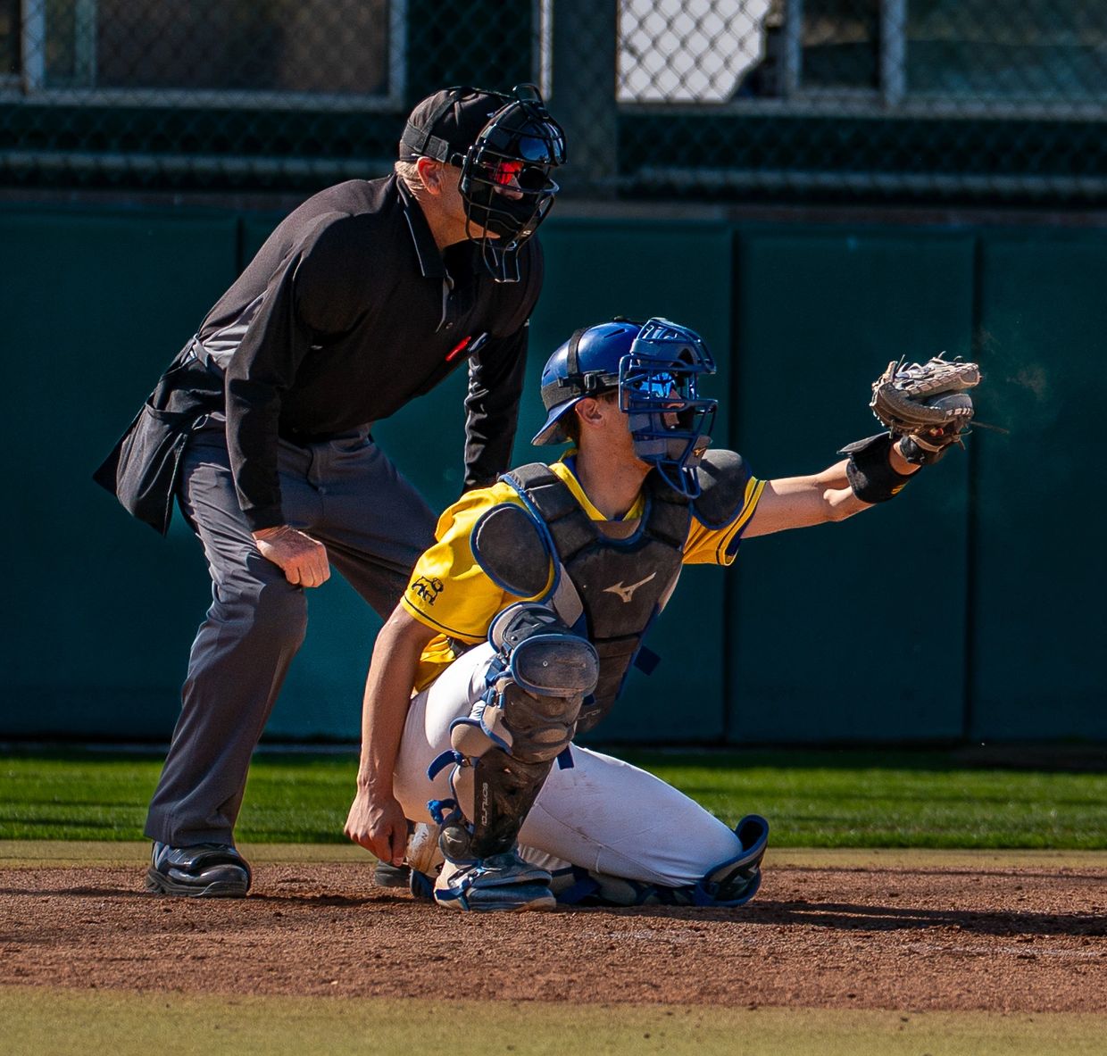 Umpire standing behind catcher.