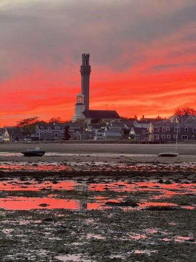 Town skyline with lighthouse at sunset.
