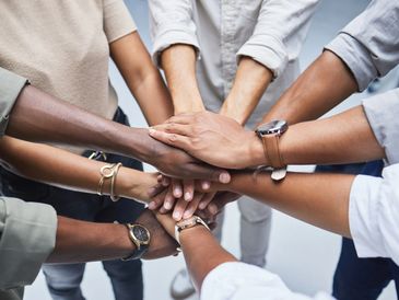 A group of women with their hands laid on top of each others