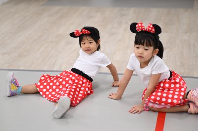 Two girls in Minnie Mouse costumes sitting on the floor.