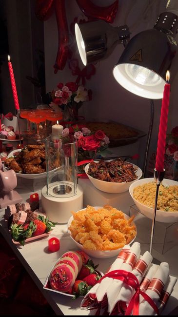 A cozy, candlelit dinner setup with various dishes and red accents.