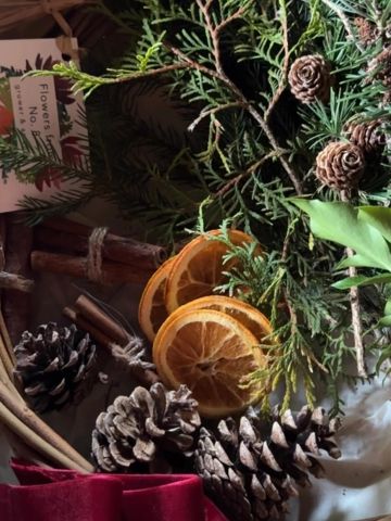 Holiday arrangement with pinecones and dried orange slices.