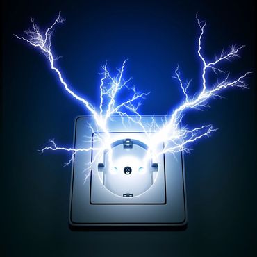 Electric sparks bursting from a wall socket in the dark.