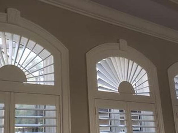 Arched interior windows with white shutters.