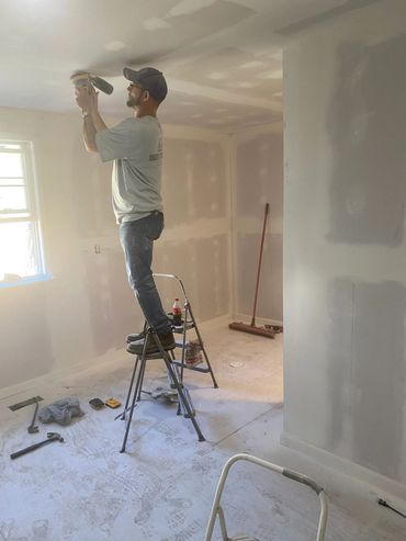 Restoration tech completing drywall finishing during an interior build-back after property damage.