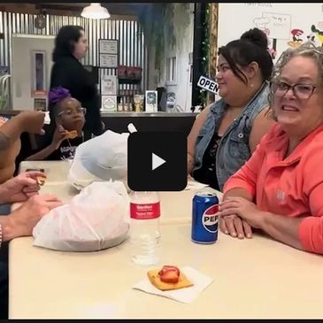 People gathered around a table enjoying snacks and drinks indoors.