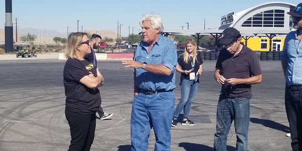 Jay Leno and Suzy having a conversation about the Suspension geek 1963 Rambler.
