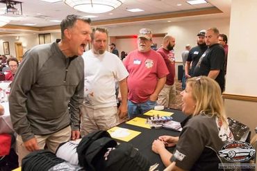 Man and woman shouting at each other at a table indoors.