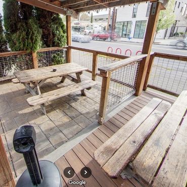 Group of friends enjoying drinks on the outdoor patio at Greeley Avenue Bar