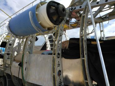 Metal structure with a blue barrel attached.