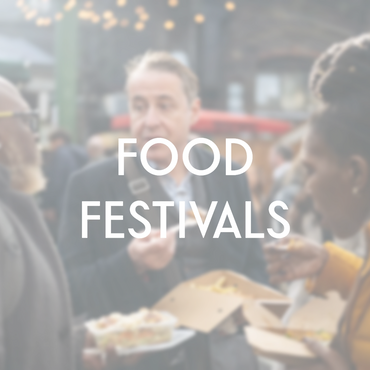 People enjoying diverse foods at a lively food festival outdoors.